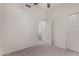 Bedroom with carpeted floor, ceiling fan, and doorway to an attached bathroom at 7940 W Taro Ln, Glendale, AZ 85308