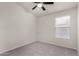 Bedroom with large window and ceiling fan with lights at 7940 W Taro Ln, Glendale, AZ 85308