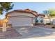 Exterior view of a stucco single-story home with a red tile roof, manicured desert landscaping, and a two-car garage at 7940 W Taro Ln, Glendale, AZ 85308