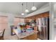 The kitchen features a stainless steel refrigerator, wooden cabinets, tile floors and a kitchen island at 7940 W Taro Ln, Glendale, AZ 85308