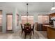 A eat-in kitchen features a wooden dining set with tile flooring, and granite countertops at 7940 W Taro Ln, Glendale, AZ 85308