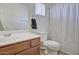 Well-lit bathroom featuring a sink, toilet and striped shower curtain at 7978 W Zoe Ella Way, Peoria, AZ 85382