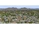Expansive aerial view of a neighborhood showcasing a mix of homes, tree-lined streets, and mountain views at 8036 N 17Th Dr, Phoenix, AZ 85021