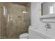 Updated bathroom features a tiled glass shower, modern sink and vanity, and a white toilet at 8036 N 17Th Dr, Phoenix, AZ 85021