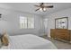 Bright bedroom with a ceiling fan, wood floors, and modern, light wood dresser with a mirror at 8036 N 17Th Dr, Phoenix, AZ 85021