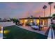 Backyard at dusk with patio area, desert landscaping, and ambient lighting at 9012 S 47Th Pl, Phoenix, AZ 85044