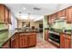 Well-lit kitchen featuring custom wood cabinets, stone countertops, and modern stainless steel appliances at 9012 S 47Th Pl, Phoenix, AZ 85044