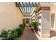 Picturesque walkway with brick pavers, lush greenery, and a charming trellis overhead at 9012 S 47Th Pl, Phoenix, AZ 85044