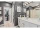 Well-lit bathroom featuring dual sinks, a mirror, and a combined shower and tub, connected to a walk-in closet at 9463 W Ross Ave, Peoria, AZ 85382