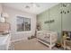 Well-lit bedroom featuring a crib, modern ceiling fan, and neutral color palette at 9463 W Ross Ave, Peoria, AZ 85382