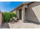 Inviting front entrance featuring a charming, covered patio area with chair and lush greenery at 9463 W Ross Ave, Peoria, AZ 85382