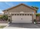 Beige single-story home featuring a two-car garage and easy maintenance desert landscaping at 9463 W Ross Ave, Peoria, AZ 85382