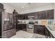 Well-equipped kitchen with stainless steel appliances, dark wood cabinets, and plenty of counter space at 9463 W Ross Ave, Peoria, AZ 85382