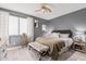 Comfortable main bedroom with wood-look floors, neutral walls, ceiling fan, and upholstered bench at 9463 W Ross Ave, Peoria, AZ 85382
