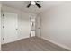 Bedroom features neutral carpet, ceiling fan, and closet at 119 E Hampton Ave, Mesa, AZ 85210