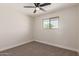 Bedroom features neutral walls, carpet, window, and ceiling fan at 119 E Hampton Ave, Mesa, AZ 85210