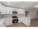 White kitchen with stainless steel appliances, updated counters, and wood-style flooring at 119 E Hampton Ave, Mesa, AZ 85210