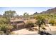 Elevated angle featuring desert home, mature trees, tile roof, and mountain views at 1305 Coyote Pass Pass, Carefree, AZ 85377