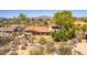 Desert home featuring a terracotta roof, covered patio, and desert landscaping with mountain views in the background at 1305 Coyote Pass Pass, Carefree, AZ 85377