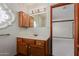 Bathroom vanity boasts warm wood cabinets, white countertop, decorative window, and a mirror at 1305 Coyote Pass Pass, Carefree, AZ 85377