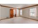 Carpeted bedroom features bright windows, wood trim detail, and a hallway leading to a bathroom at 1305 Coyote Pass Pass, Carefree, AZ 85377