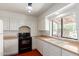 Well-lit kitchen with white cabinets and black appliances under a decorative light fixture at 1305 Coyote Pass Pass, Carefree, AZ 85377