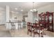 Open-concept dining area with a traditional table and a kitchen island with bar seating at 13569 S 175Th Dr, Goodyear, AZ 85338