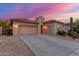 Desert home showcasing a spacious three-car garage, neutral color palette, and low maintenance landscaping at 13569 S 175Th Dr, Goodyear, AZ 85338