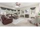 Spacious living room with a fireplace, plush seating, and natural light streaming through the large windows at 13569 S 175Th Dr, Goodyear, AZ 85338