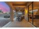 Covered outdoor patio area with ceiling fan, seating, and sliding glass door to home at 13569 S 175Th Dr, Goodyear, AZ 85338