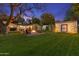 Spacious backyard with a fire pit area, lush green lawn, and a storage shed, ideal for outdoor activities at 141 E Bonita Way, Tempe, AZ 85281