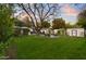 Spacious backyard with lush green grass, mature trees, and a cozy fire pit area at 141 E Bonita Way, Tempe, AZ 85281