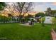 Beautiful backyard featuring a fire pit area, mature trees, and a well-maintained lawn at 141 E Bonita Way, Tempe, AZ 85281