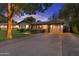 Charming house with a well-manicured lawn, a brick pathway, and a paved driveway leading to a garage at dusk at 141 E Bonita Way, Tempe, AZ 85281