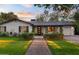 Charming home with a modern front door, lush lawn, and brick pathway, radiating curb appeal at 141 E Bonita Way, Tempe, AZ 85281
