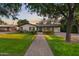 Well-maintained home with a manicured lawn, brick pathway, and a charming facade under a clear sky at 141 E Bonita Way, Tempe, AZ 85281