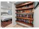 Hallway with built-in bookshelves filled with books, leading to a bedroom with natural light at 141 E Bonita Way, Tempe, AZ 85281