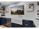 Close-up of a kitchen sink with white countertops, navy cabinets, and a window overlooking the backyard at 141 E Bonita Way, Tempe, AZ 85281