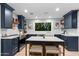 Modern kitchen featuring navy cabinets, a white tile backsplash, stainless steel appliances, and a kitchen island at 141 E Bonita Way, Tempe, AZ 85281