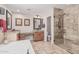 Well-lit bathroom with a soaking tub, glass-enclosed shower, and double sink vanity at 14294 W Edgemont Ave, Goodyear, AZ 85395