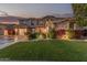 Charming home exterior with lush landscaping, well-manicured lawn and warm inviting lighting at 14294 W Edgemont Ave, Goodyear, AZ 85395