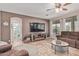 Comfortable living room with large TV, ceiling fan and views of the backyard at 14294 W Edgemont Ave, Goodyear, AZ 85395