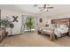 Main bedroom with ceiling fan, balcony access, and a wooden accent wall behind the bed at 14294 W Edgemont Ave, Goodyear, AZ 85395