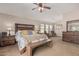 Spacious main bedroom with a sitting area, ceiling fan, and stylish furnishings at 14294 W Edgemont Ave, Goodyear, AZ 85395