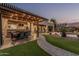 Inviting outdoor living area with bar seating, pergola and string lights for evening enjoyment at 14294 W Edgemont Ave, Goodyear, AZ 85395