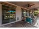 Covered patio with ceiling fans, sliding glass doors, and comfortable outdoor seating at 14294 W Edgemont Ave, Goodyear, AZ 85395