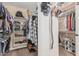Spacious walk-in closet with organized shelves and hanging racks for optimal storage at 14294 W Edgemont Ave, Goodyear, AZ 85395