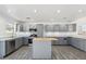 Well-lit kitchen featuring gray cabinets, stainless steel appliances, island, and neutral countertops and backsplash at 1466 E Avenida Fresca --, Casa Grande, AZ 85122