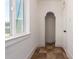 Hallway with tile flooring, an arched entryway, and a door, providing a seamless transition between spaces at 1505 W Fillmore St, Phoenix, AZ 85007