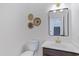 Stylish half bath with a modern mirror, gold faucet, and decorative wall baskets adding a touch of elegance at 1612 E Desert Rose Trl, San Tan Valley, AZ 85143